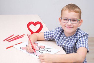 Sevgililer gününde, bir çocuk hediye olarak kalp çizer.