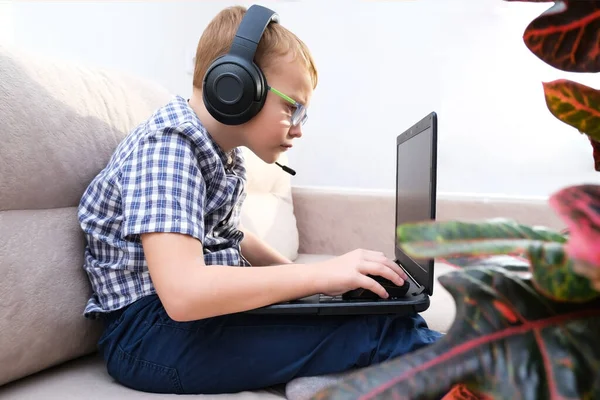 Chico Con Auriculares Está Sentado Sofá Jugando Computadora —  Fotos de Stock