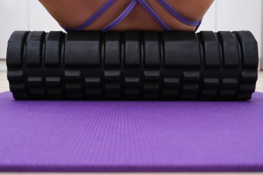 Çok Peri renginde takım elbiseli bir kız sırt masajı yapar, bir topla, miyofasyal gevşeme ile.