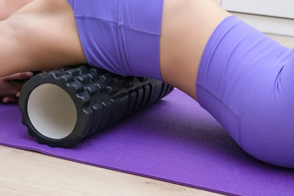 Bir kız masaj makinesiyle sırt masajı yapar, miyofasyal gevşeme.