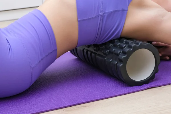 Bir kız masaj makinesiyle sırt masajı yapar, miyofasyal gevşeme.