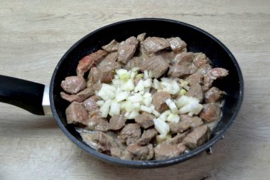 Ete ince doğranmış soğan ekle, kızartmaya devam et..