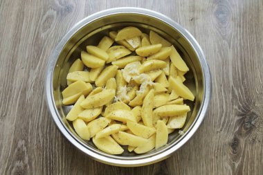 Patatesli bir kaseye doğranmış sarımsak koy, sebze yağı ekle ve iyice karıştır..