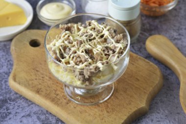 Konserve yiyecekleri çatalla doğra, büyük kemikleri ayır. Bir sonraki konserve yiyeceği tabakasını yay. Sosla doymuş..