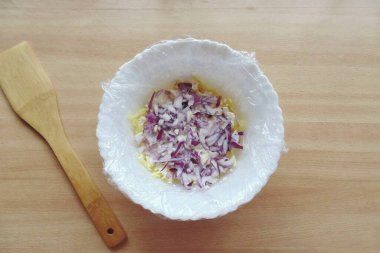 Kırmızı soğan ya da herhangi bir salata kabuğu, yıka ve güzelce doğra. İkinci bir marul katmanıyla dağılın..