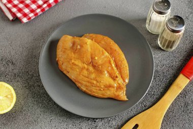 Göğsü tuz ve baharatla ovala, limon suyunun üzerine dök, sebze yağı serp ve 20-30 dakika salamura et..