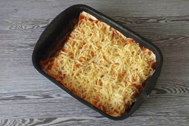 Ekmeği kalan sosla yağla, rendelenmiş peynir serpin. Fırında önceden 180 dereceye 20 dakika ısıtılmış fırın. Fırınınızın özelliklerini düşünün.!