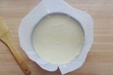 Parşömeni ikiye böl. Bisküvi bir su banyosunda pişecek, bu yüzden tenekeyi iki kat folyoya sar ki suyun hamura karışmasını önlesin. Formun kenarlarını parşömenle oluşturun. Mangırı kalıba dök. M 'nin çapı