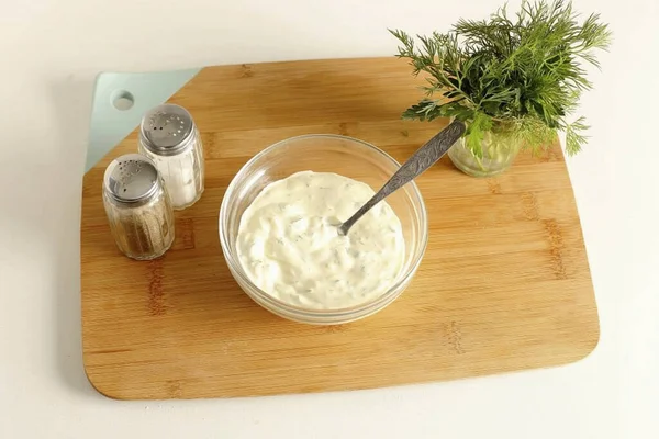 Ekşi kremayla mayonezi karıştır. Kıymalı sarımsak ve şifalı ot ekle. Sos hazır..