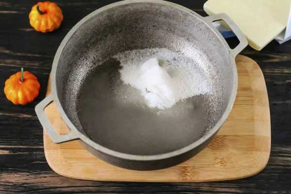 Pour sugar into a cauldron or saucepan, add water and place the container on the stove, adding a little lemon juice and salt.