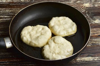 Kenarları bağlayın, çörekleri kızartma tavasına koyun, sebze yağını ısıtmak için..