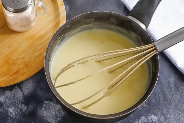 While the dough is resting, pour milk of any fat content into another container with a non-stick bottom, add the chicken yolk, add sugar and wheat flour. Whisk everything gently and place the container on the stove. When adding flour, milk must be co