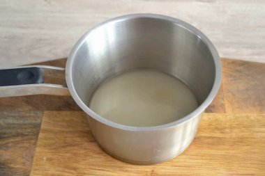 Tencereye şeker dök, su ekle, orta sıcaklıkta ısıt, karıştırma, sadece tencereyi yana yatır..