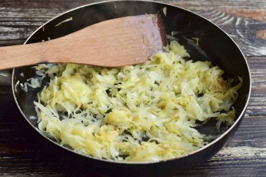 Kızartma tavasında lahana haşla, üzerine 7-10 dakika boyunca sebze yağı ya da su dök. Birkaç tutam tuz ekle..