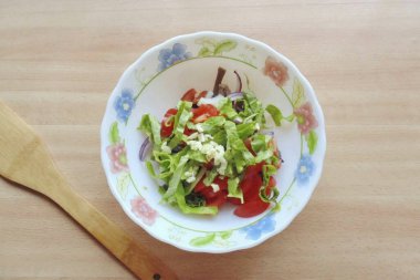 Marul yaprağını yıka ve ellerinle küçük parçalara ayır ya da kes. Doğranmış sarımsak ekle.