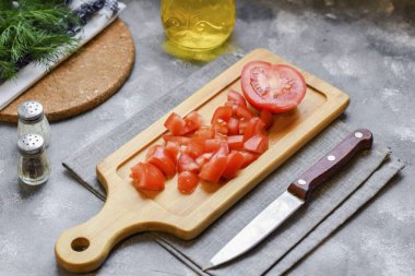 Domatesleri yıka, kurut, sapın büyüdüğü yeri kaldır. Domatesleri küçük küp ya da kama şeklinde kes.