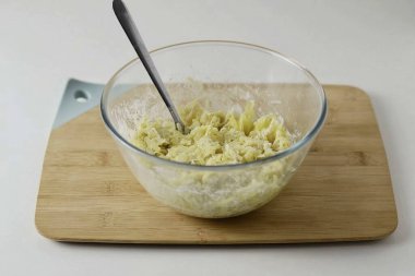 Büyük bir kasede, patatesleri un, tuz ve biberle birleştir. Karıştır.