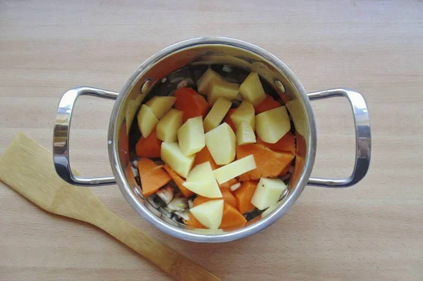 そしてジャガイモをみじん切り それは完全に野菜をカバーしないように鍋に水を注ぐ — ストック写真