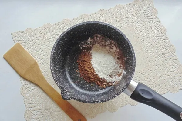 While the cake is baking, make a cream. Place the cocoa powder and cornstarch in a heavy-bottomed saucepan. If there is no corn, then replace it with flour, but not with potato starch.