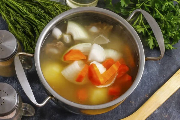 Soğan ve havuçları büyük parçalara ayır, kabın içine ekle ve 5 dakika daha kaynat. Tuz ve karabiber ekle..