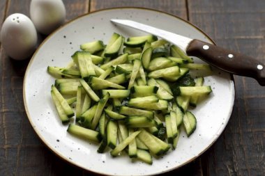 Taze salatalıkları ince dilimlere ayırın..