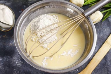 Un ve kabartma tozu ekle. İçindekileri yavaşça çamura karıştır, ama çırpma. Hamur çok kalın olmalı, yoğun, ekşi krema gibi..