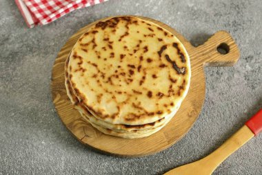 Bitmiş kepekli kekleri tereyağlı ve üst üste yığarak yağlayın. Bu şekilde, bir çantaya sarılmış ya da havluyla örtülmüş ve 10-15 dakikalığına ayrılmış olmalılar..