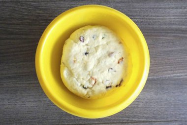 Bitmiş hamur yumuşak, esnek olmalı, ellerine yapışmamalı. Yuvarla, bir kaseye koy, havluyla ört ve 2 saat boyunca sıcak, cereyansız bir yere koy..