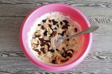 Karıştırırken, kurutulmuş meyve ve fındık karışımını da ekleyin. Kalan unu da ekle. Ellerinle diz çök..
