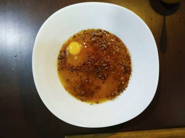 Hamuru yoğurmak için her şeyi derin bir kaseye dökün. Yumurtayı ekle ve her şeyi çırp..