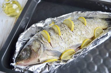 Folyodan bir tekne yaptık, iki kat kalın folyo kullandım ki balık suyu akmasın. Keselim, limon dilimleri koyalım, bir de limon koyalım. Sıcak bir fırına (200 derece) 20-30 dakika, balığın boyutuna bağlı olarak yerleştirilir.