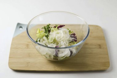 Salamurayı boşalt, soğan turşusunu salata karışımıyla birleştir. Salatayı yağla doldur, karıştır.