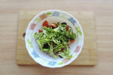 Marul ve maydanoz dilimleri. Salata kasesine ekle.