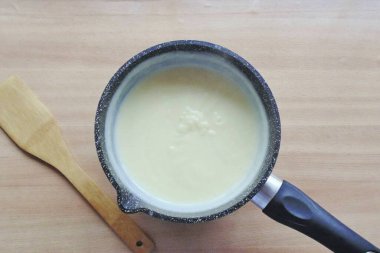 Sütü tencereye dök ve ocağın üstüne koy. Kaynatın ve yumurta sarısı, şeker ve nişasta karışımı koyun. Sürekli karıştırırken, kremi kalınlaştırın..