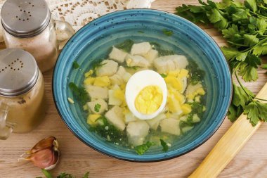 Kaynamış yumurtanın yarısını küp küp doğra. Çorbayı derin kaselere dök, yumurta dilimlerini koy, kaynamış yumurtanın yarısını ortaya koy ve çorbayı sıcak servis et. Ekşi kremayla her türlü yağ içerir..