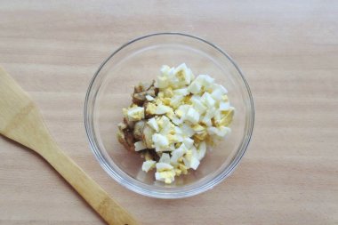 Yumurtaları kaynatın, soğutun ve soyun. Küpleri kes ve patlıcan kasesine ekle..