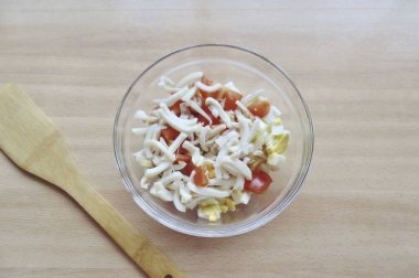 Mürekkep balığını soy, yıka, kaynar su koy. Tam olarak 3 dakika pişir ve tavadan uzaklaş. Buzdolabını doldur ve şeritleri kes..