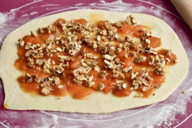 Katmanı reçelle yağla ve cevizleri üstüne koy..