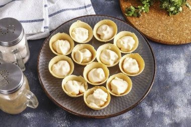 Tartletler hem kum hem de gofret satın alınabilir ama unutma ki ikincisi çok çabuk ıslanır ve nemi emer. Bu yüzden, servis etmeden önce aperatifleri hazırlayın. İşlenmiş peyniri tartların içine koy..