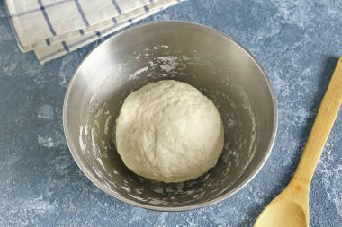 Sıkı ve elastik bir hamur diz çökün. Topla topla, havluyla ört ve 20 dakika otur..