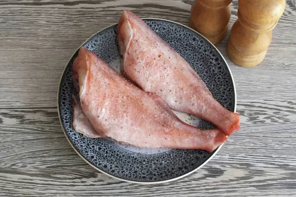 把鱼准备好洗净 摘掉鳞片 摘下鱼鳍 用纸巾擦干帕特 用盐和胡椒调味 在你准备其他食物的时候 把鱼擦干净 让它坐着 — 图库照片