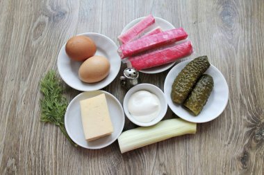 Pırasa ve yengeç salatası yapmak için gerekli tüm malzemeleri hazırlayın. Yumurtaları önceden kaynatıp soğut..