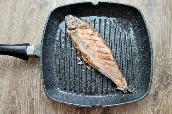烧热烤盘 用植物油刷一下 把每一边的鳟鱼煎上一分钟 转到盘子上 — 图库照片