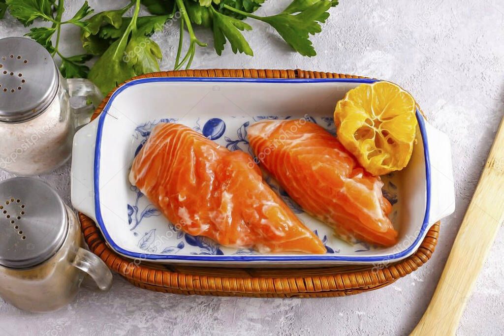 Wash the salmon fillet in water and pat dry with paper towels. Place in a deep container and squeeze the lemon juice out of a portion of the lemon, pre-cutting 3-4 slices for baking. Add salt and ground black pepper. Thoroughly fry the fish pieces in