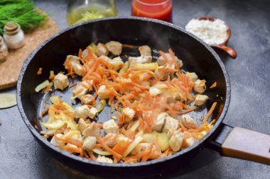 Kızartma tavasında biraz yağ ısıt, soğan, havuç ve et koy. Birkaç dakika kızart, ara sıra karıştır..