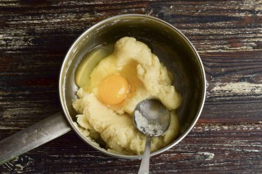 Yumurtaları birer birer tencereye çırpın. Hamuru iyice karıştır..