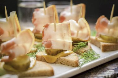 Pastırmalı kanepeler ve salatalık turşusu hazır! Bu kanepeler örneğin bir tabak sıcak borş ya da çorba ile şenlikli ya da günlük bir masada servis edilebilir..