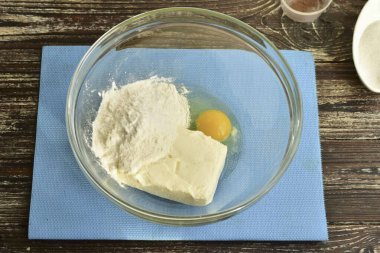 Bir kaseye tavuk yumurtası koy, süzme peynir ekle, tuz ve un ekle..