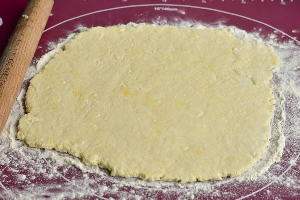 Put the dough on a silicone mat, roll it into a layer with a rolling pin.