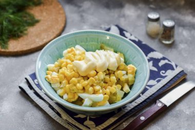 Mayonezli mevsim salatası. Tadına tuz ve biber ekle. Her şeyi karıştır ve salatayı masaya getir..